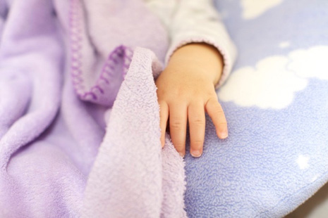 infant hand on blanket